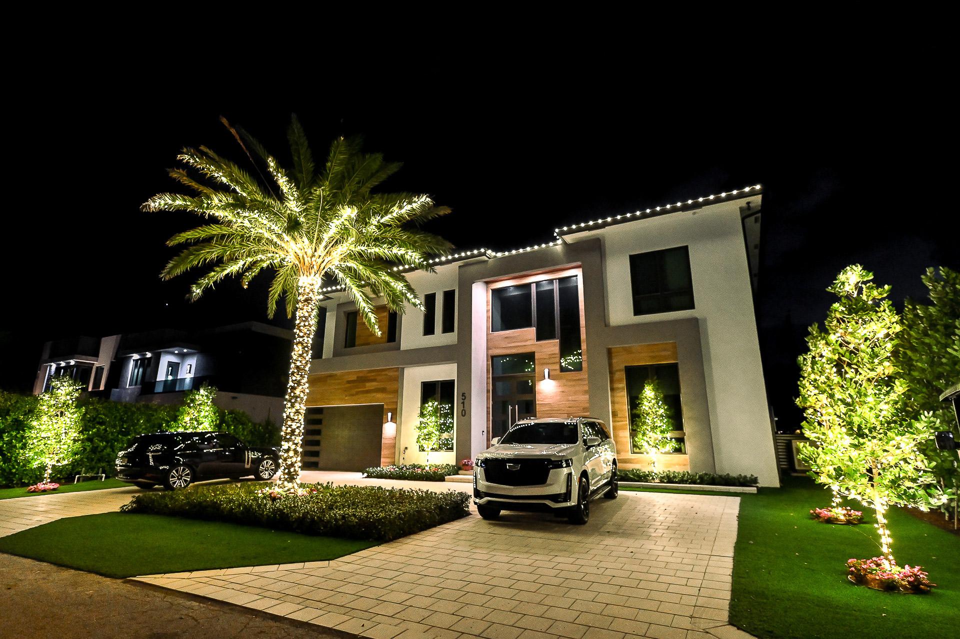 Palm trees wrapped in holiday lighting outside a South Florida home