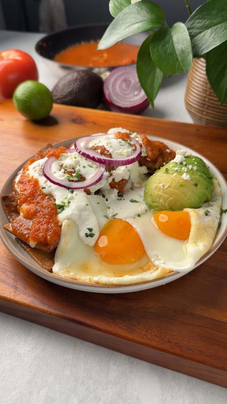 Chilaquiles rojos con huevo estrellado, aguacate y cebolla morada