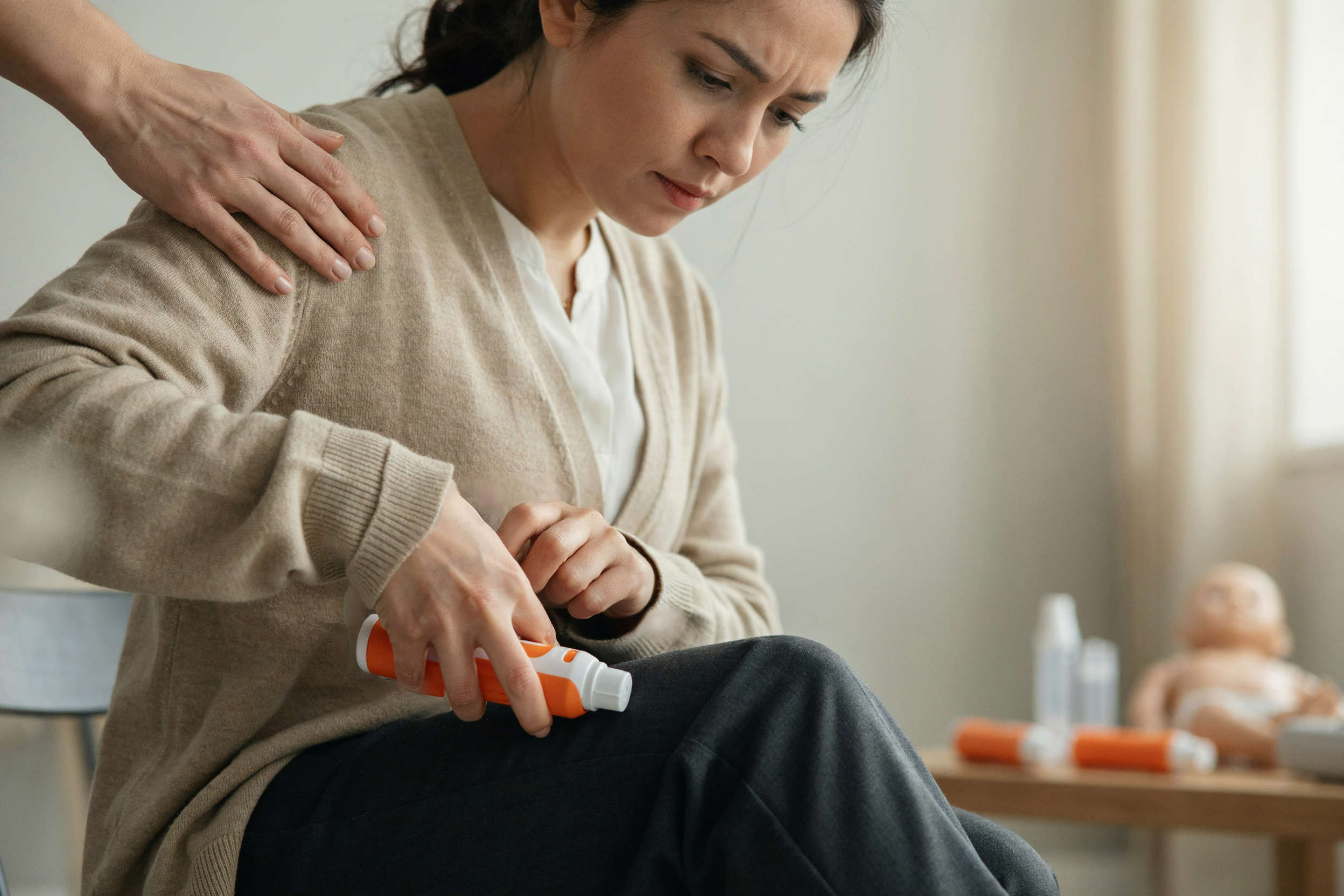 Pressing a trainer autoinjector against your own thigh