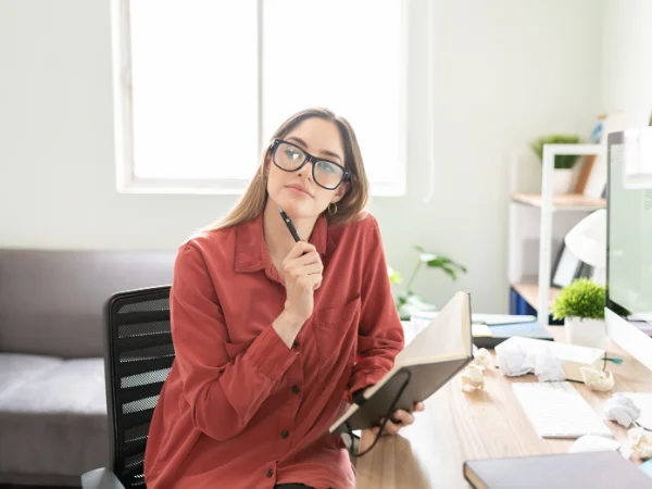 Professional woman planning content at her desk, representing the importance of author bios and expertise signals in building credibility.
