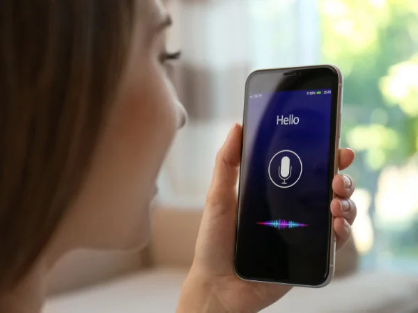 Close-up of woman using a voice assistant on smartphone, representing natural language and voice search optimisation.