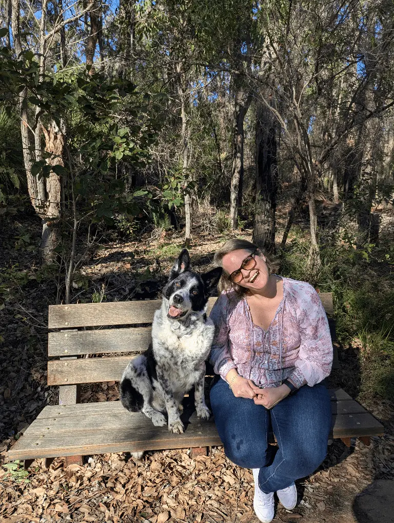 Ellie and her dog Monty on a bench in the bush