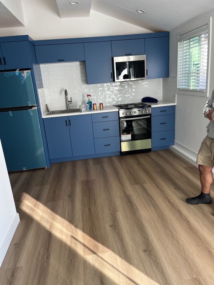 Kitchenette with navy cabinets inside a garage converted into an ADU
