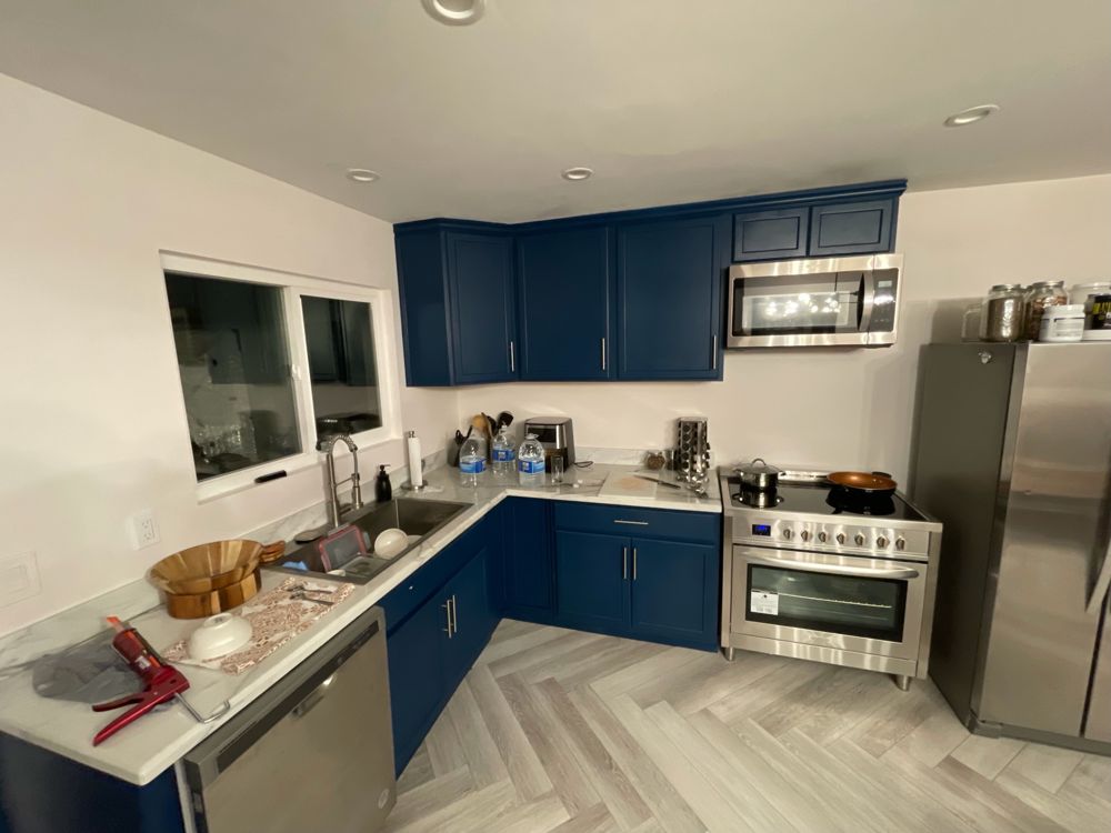 Opened-up kitchen with navy cabinets in Eric's home