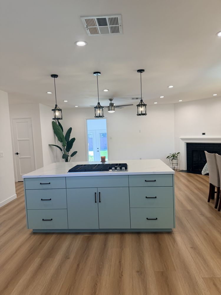 Sage green kitchen island with a downdraft cooktop in Miguel's home