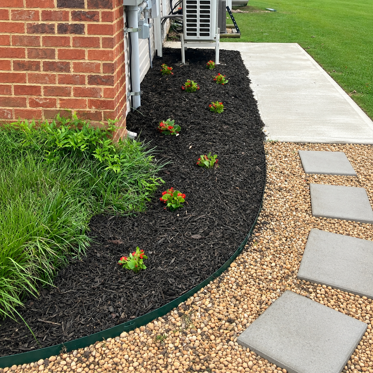 Landscaped flower bed with dark mulch and flowers