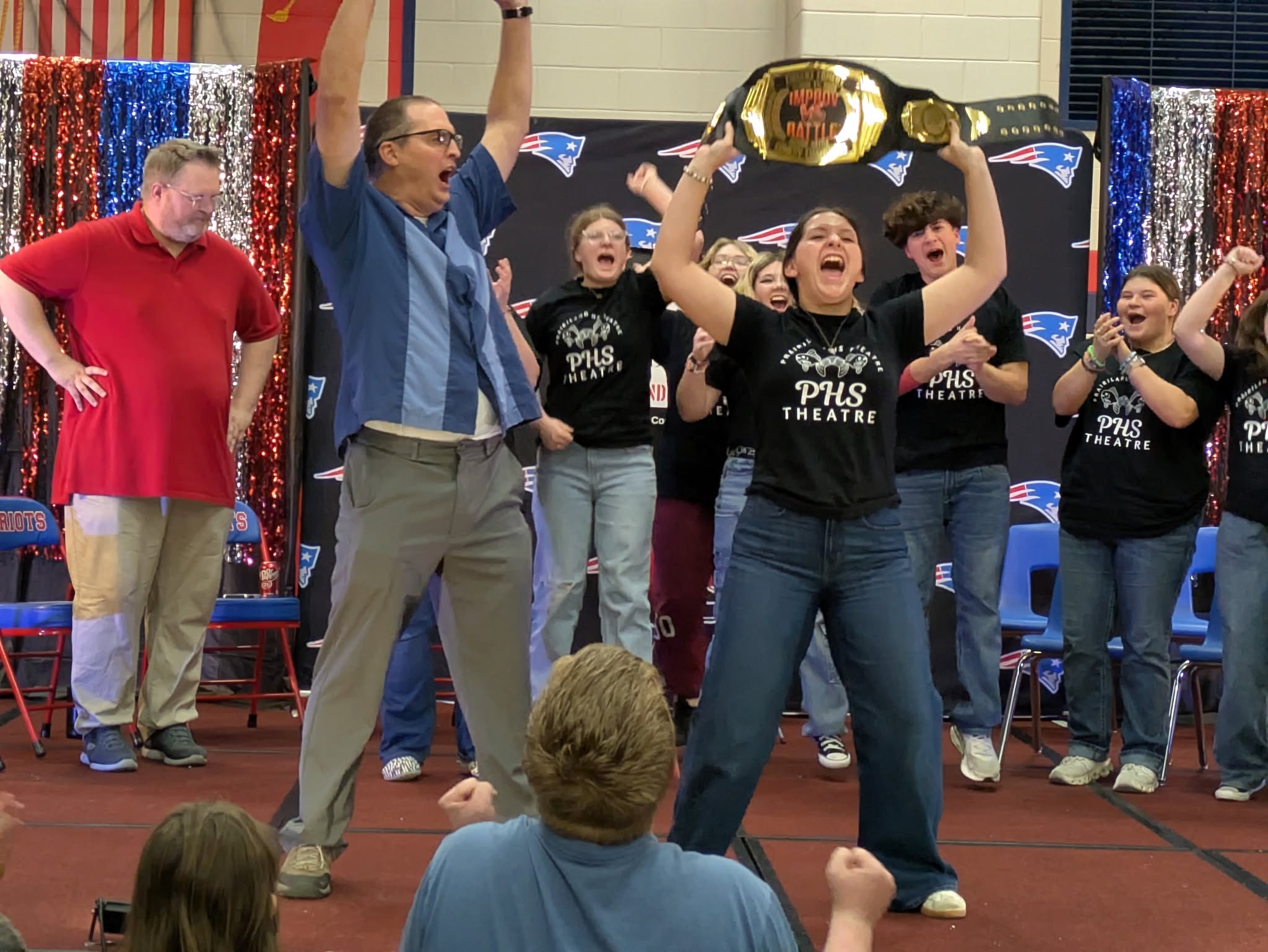 PHS Theatre students celebrating with the Improv Battle championship belt raised overhead