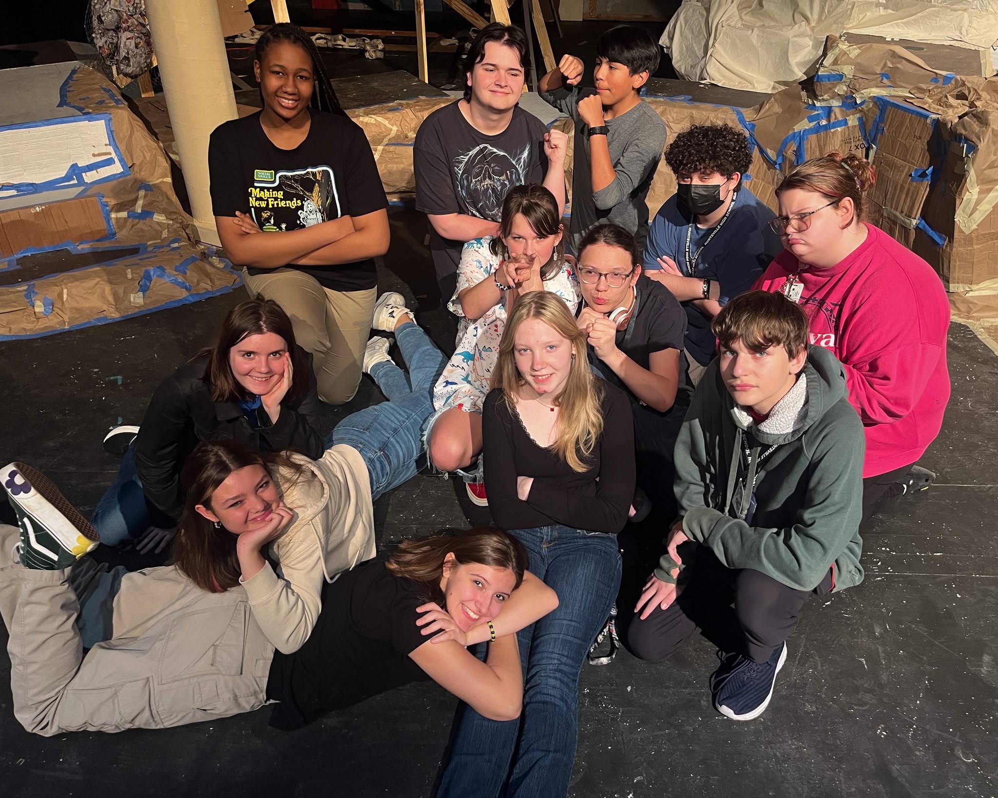 Student cast posing together backstage before an interactive play