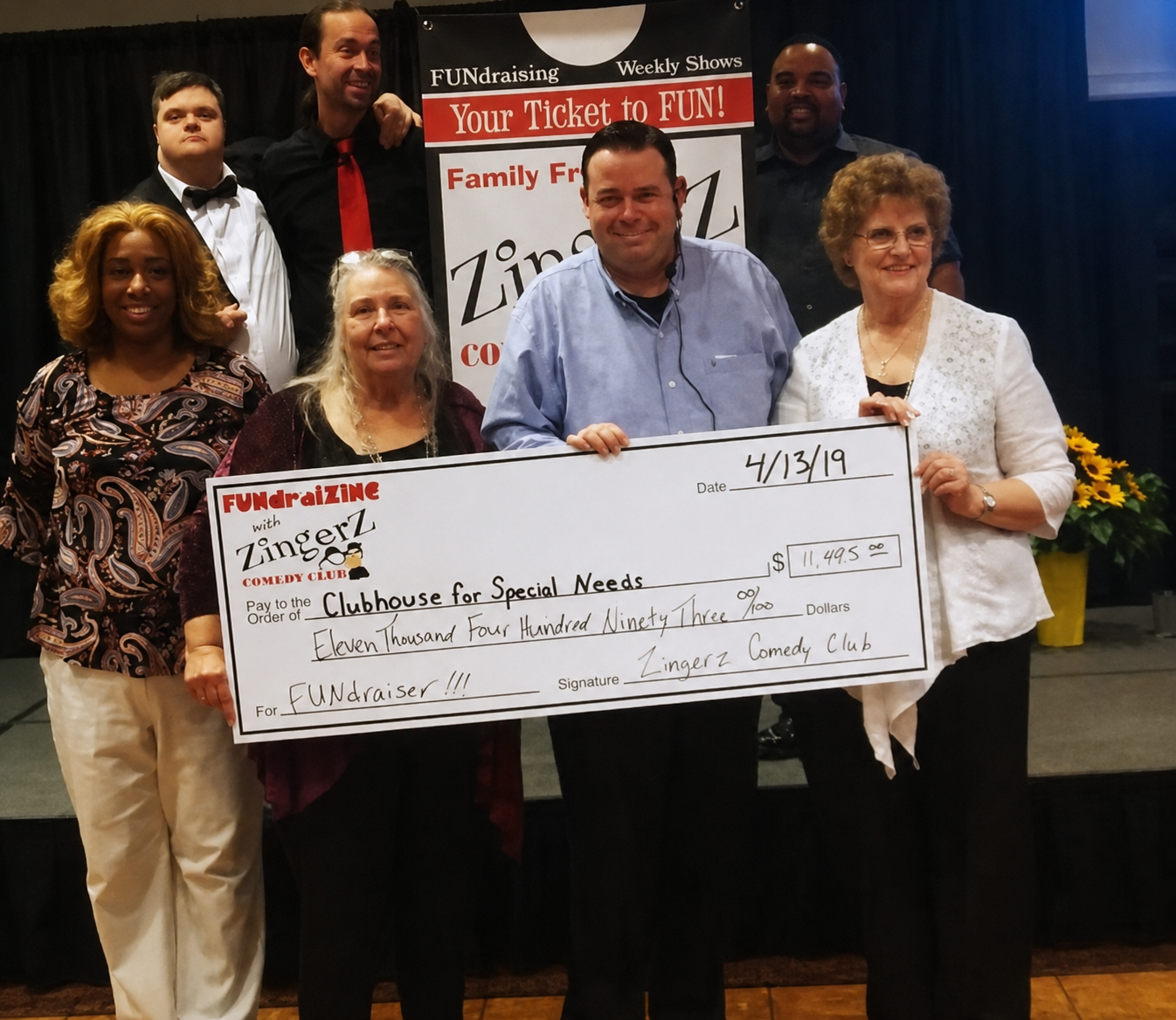 Organizers holding a big ZingerZ check for $11,493 raised for Clubhouse for Special Needs