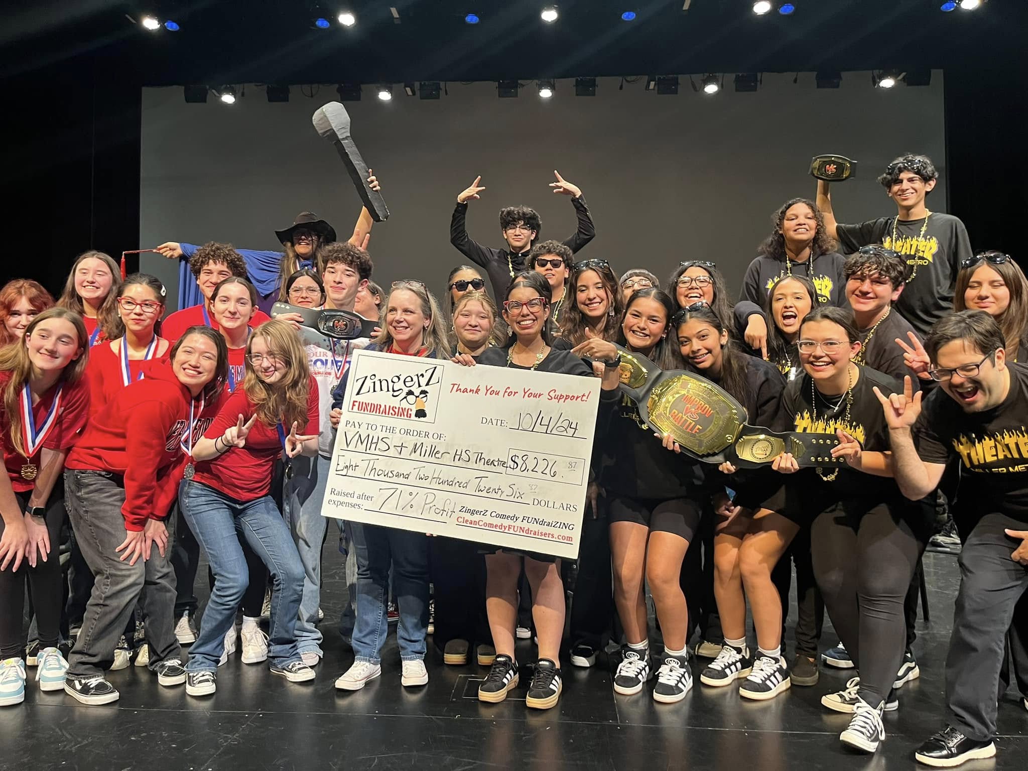 Two school theater programs celebrating on stage with an $8,226 ZingerZ FUNdraising check