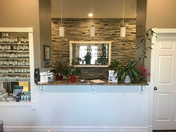 Front desk with stone wall at Five Points Chiropractic