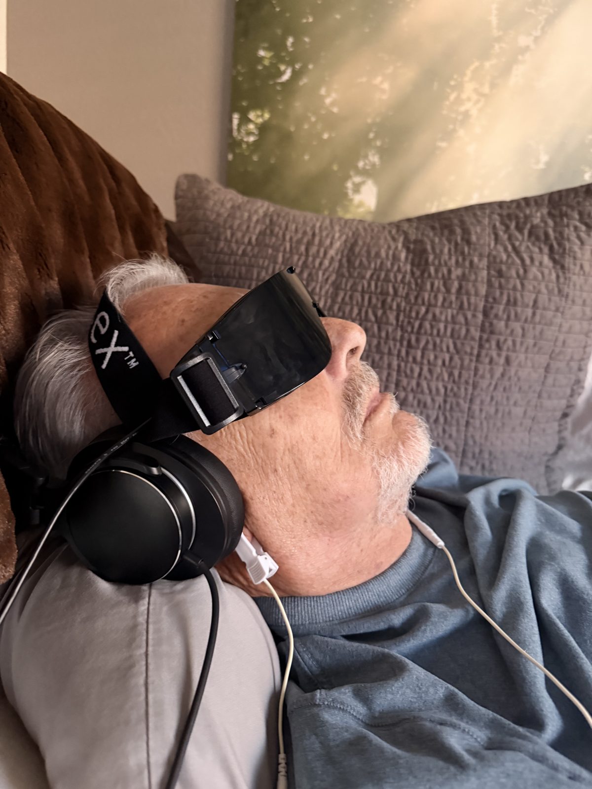 Guest relaxing with headphones and eye mask during an AO Infinity HUB session