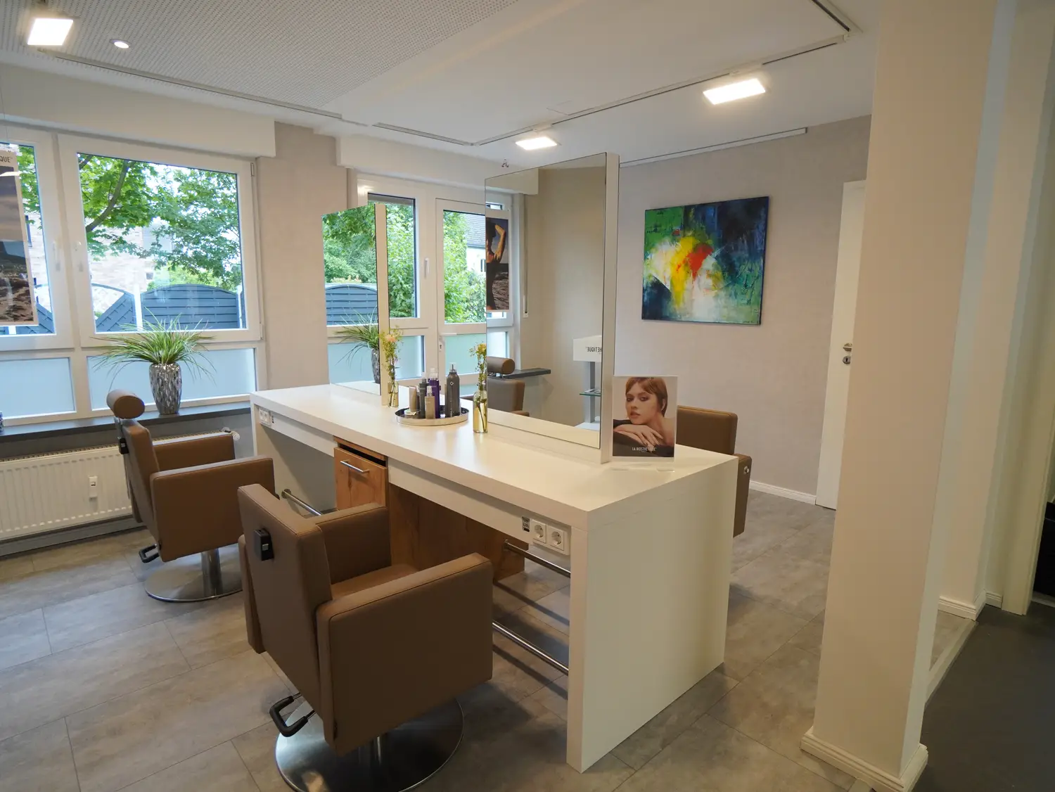 Styling-Bereich mit Arzu Hairstyle & Beauty Holzlogo im Friseursalon in Lippstadt