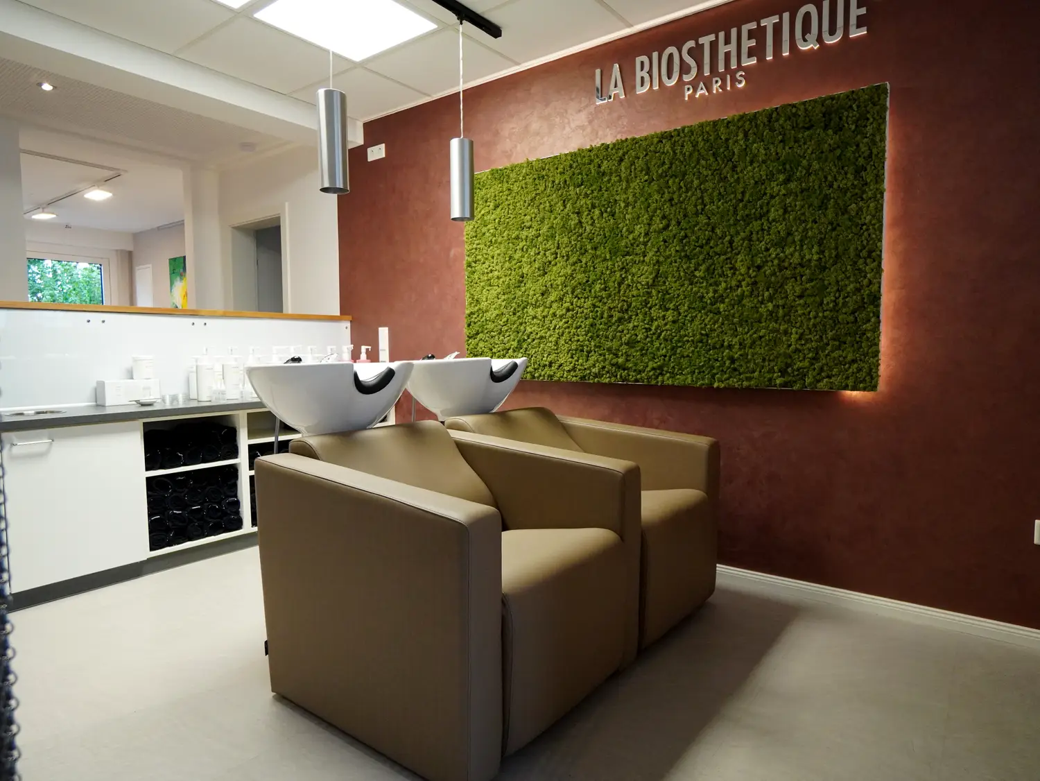 Komfortable Waschplaetze vor begruenter Mooswand mit La Biosthetique Branding, Friseursalon Lippstadt