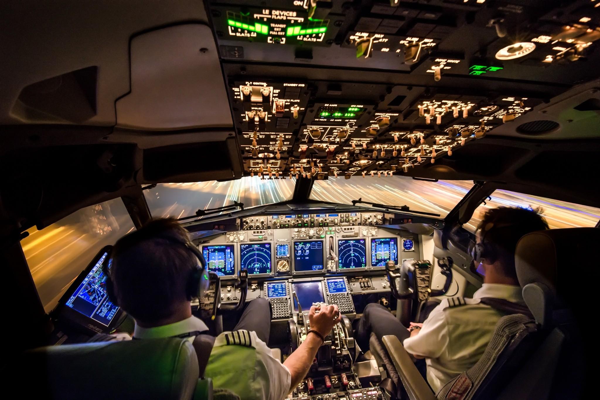 Airline pilots training in a Boeing 737 simulator cockpit at night