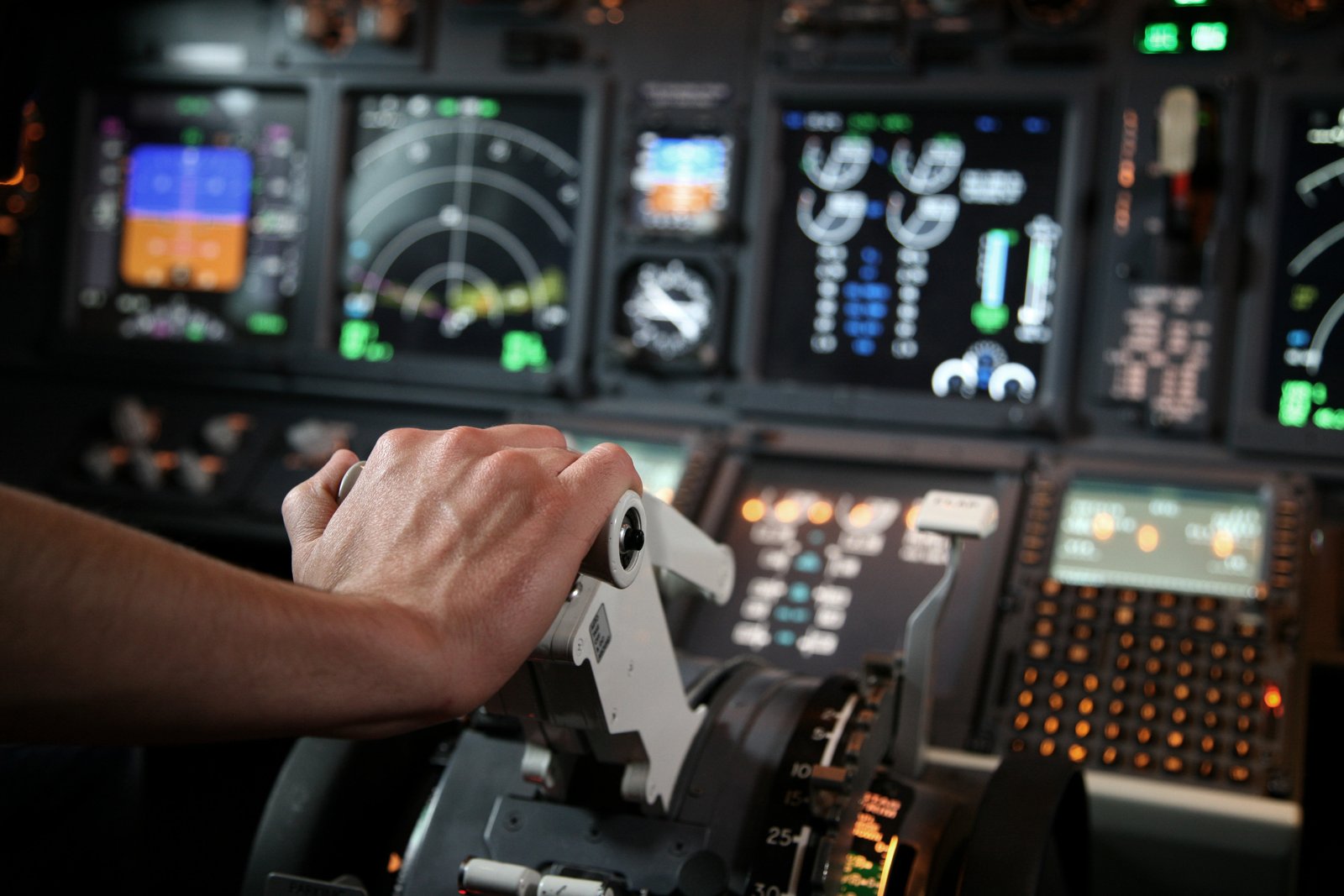 A pilot's hand on the thrust levers of an airliner