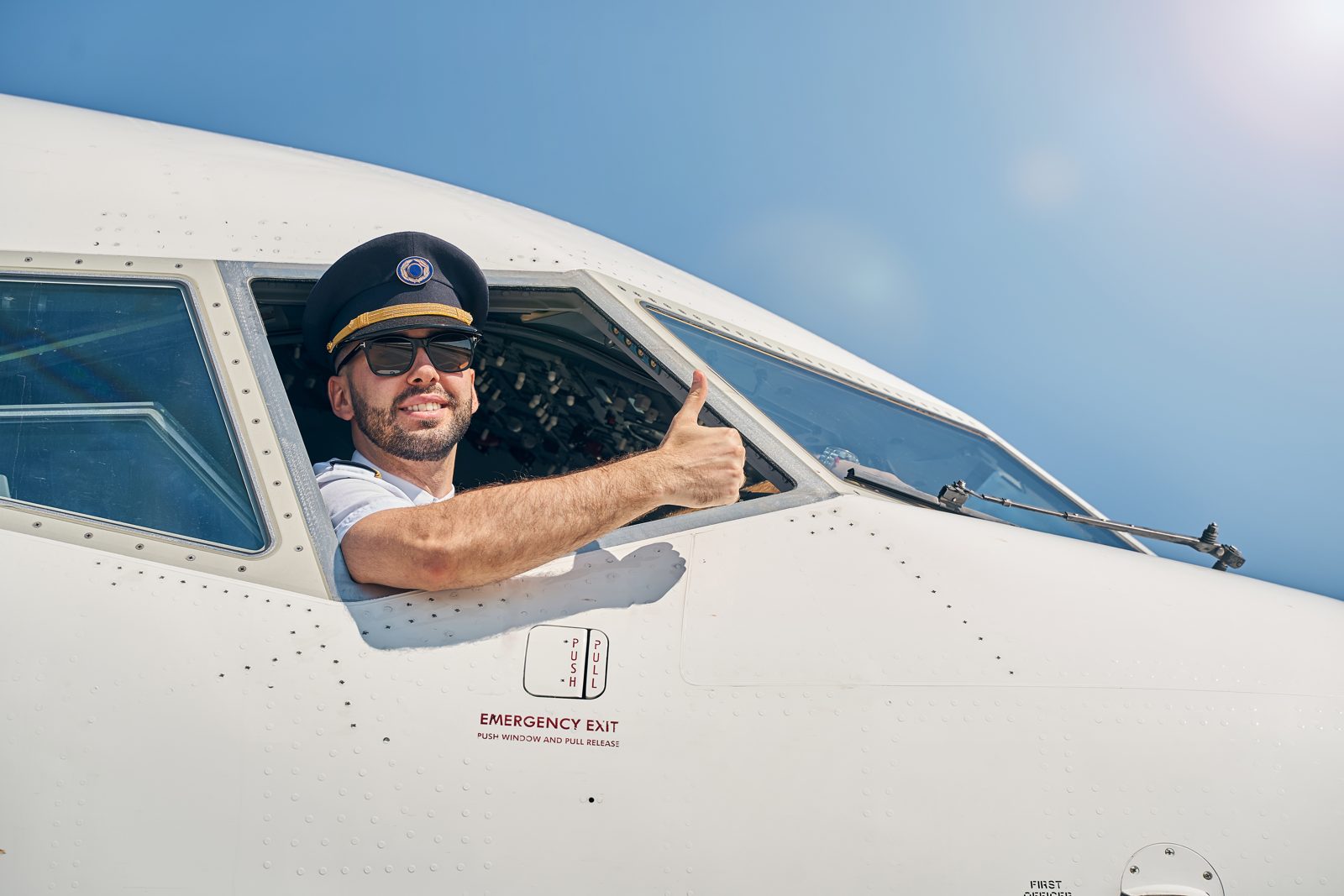 A pilot giving a thumbs-up from the flight deck window