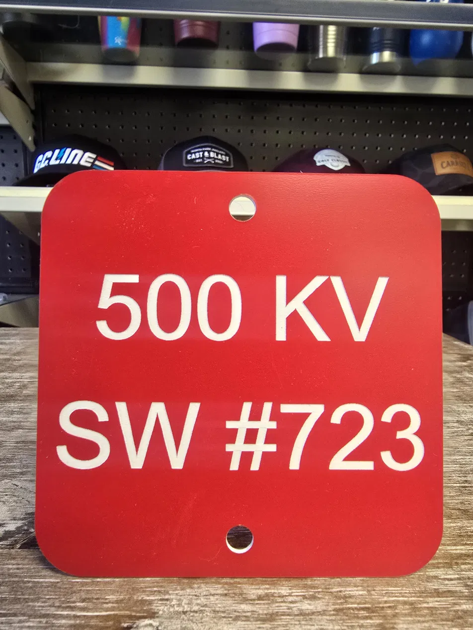 Engraved 500 KV utility switch identification tag on red phenolic material