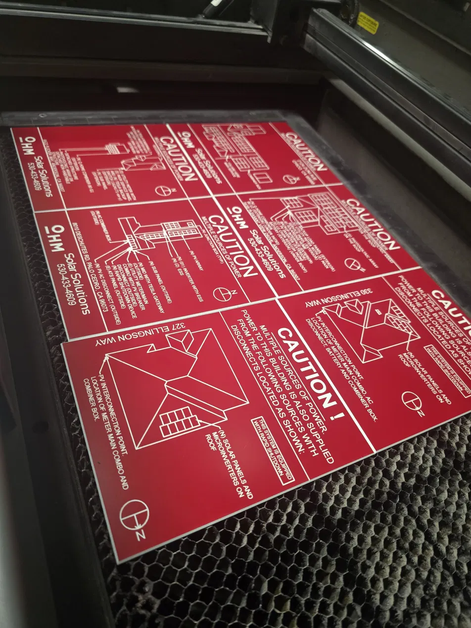 Engraved two-ply phenolic compliance labels in production on Recognition Products laser bed