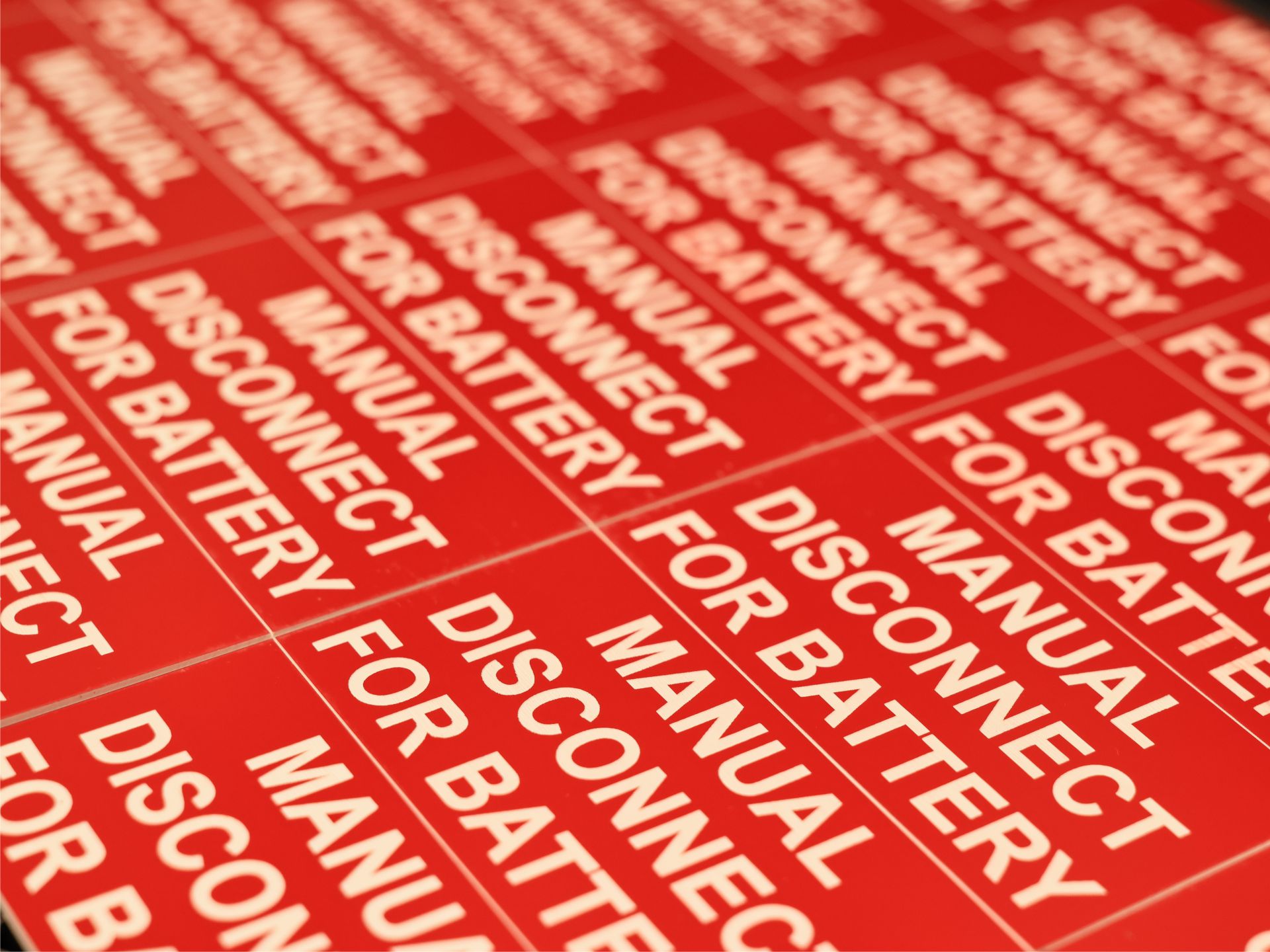 Engraved red manual disconnect for battery plates repeating across a production sheet