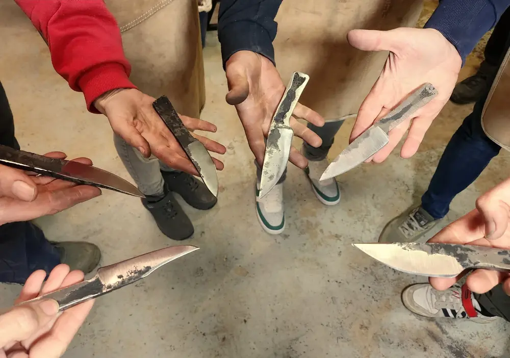 Alumnos mostrando los cuchillos de herrero que acaban de forjar