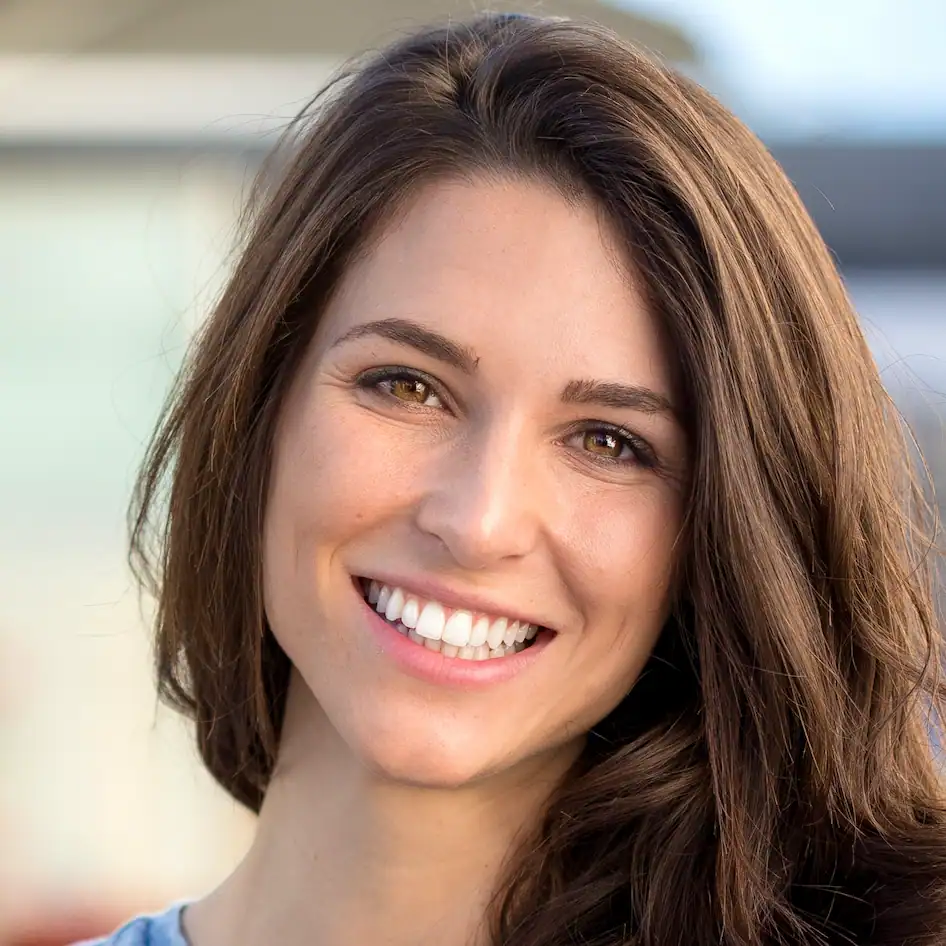 Lachende Patientin mit festen Zähnen nach Zahnimplantaten