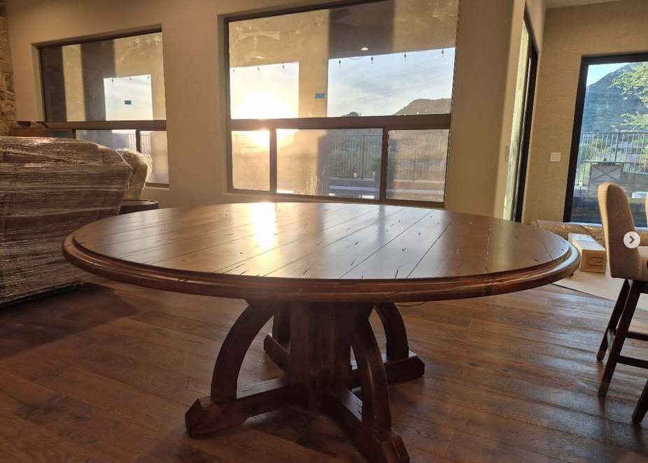 Finished walnut pedestal dining table in a warm home at golden hour