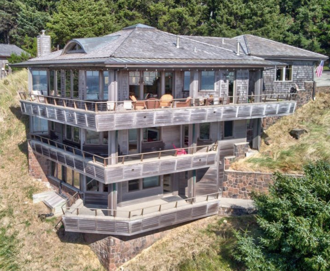 Three-story ocean-facing elevation of Cannon Beach home before renovation showing weathered cedar shakes and aged decking