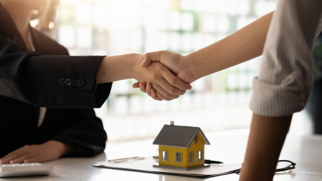 A close-up of two professionals shaking hands across a desk with a miniature house and real estate documents in the foreground. The image represents successful investment partnerships, property transactions, and the trust established during real estate syndication and acquisitions. It supports topics such as multifamily syndication, commercial real estate investing, partnership agreements, investment due diligence, sponsor-investor relationships, capital raising, and how to evaluate multifamily syndication deals in Albany NY. A close-up of two professionals shaking hands across a desk with a miniature house and real estate documents in the foreground. The image represents successful investment partnerships, property transactions, and the trust established during real estate syndication and acquisitions. It supports topics such as multifamily syndication, commercial real estate investing, partnership agreements, investment due diligence, sponsor-investor relationships, capital raising, and how to evaluate multifamily syndication deals in Albany NY.