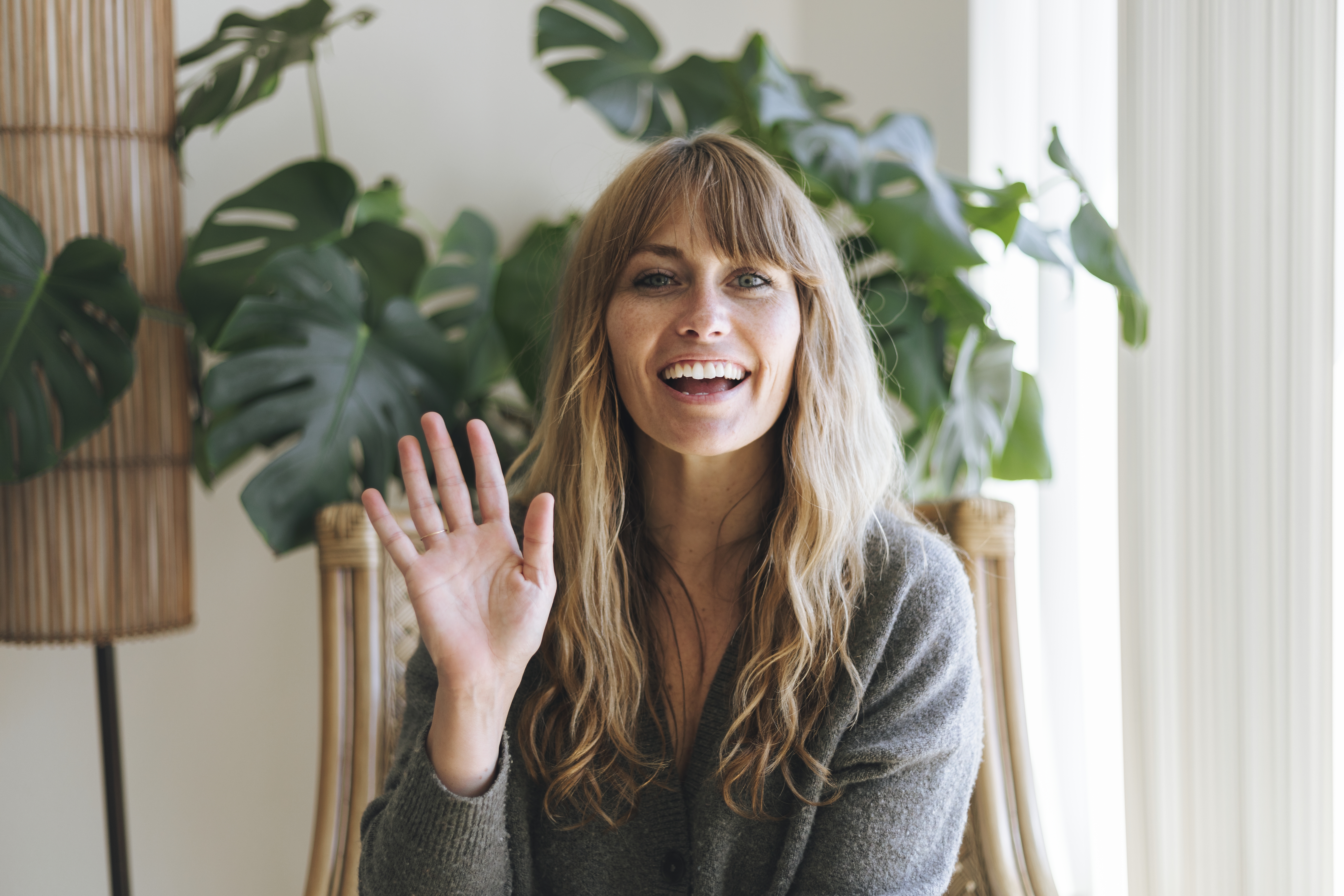 Blonde woman waving and smiling