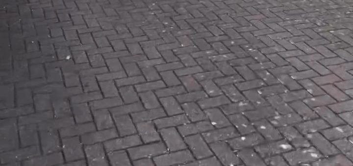 Before: grey block paving with pale spots across a driveway
