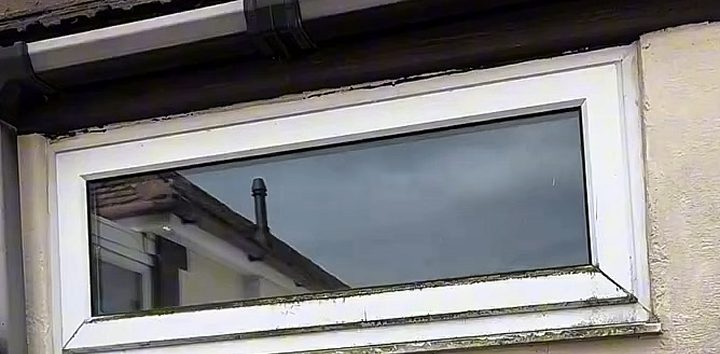 Before: a window under the gutter, with green and black marks on the white frame and sill