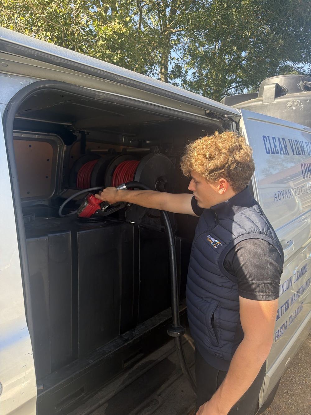 Dylan filling a van's water tank with purified water at our base