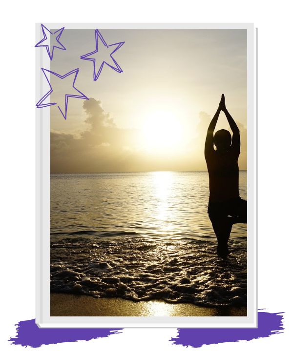 person standing in tree pose with the ocean lapping around them