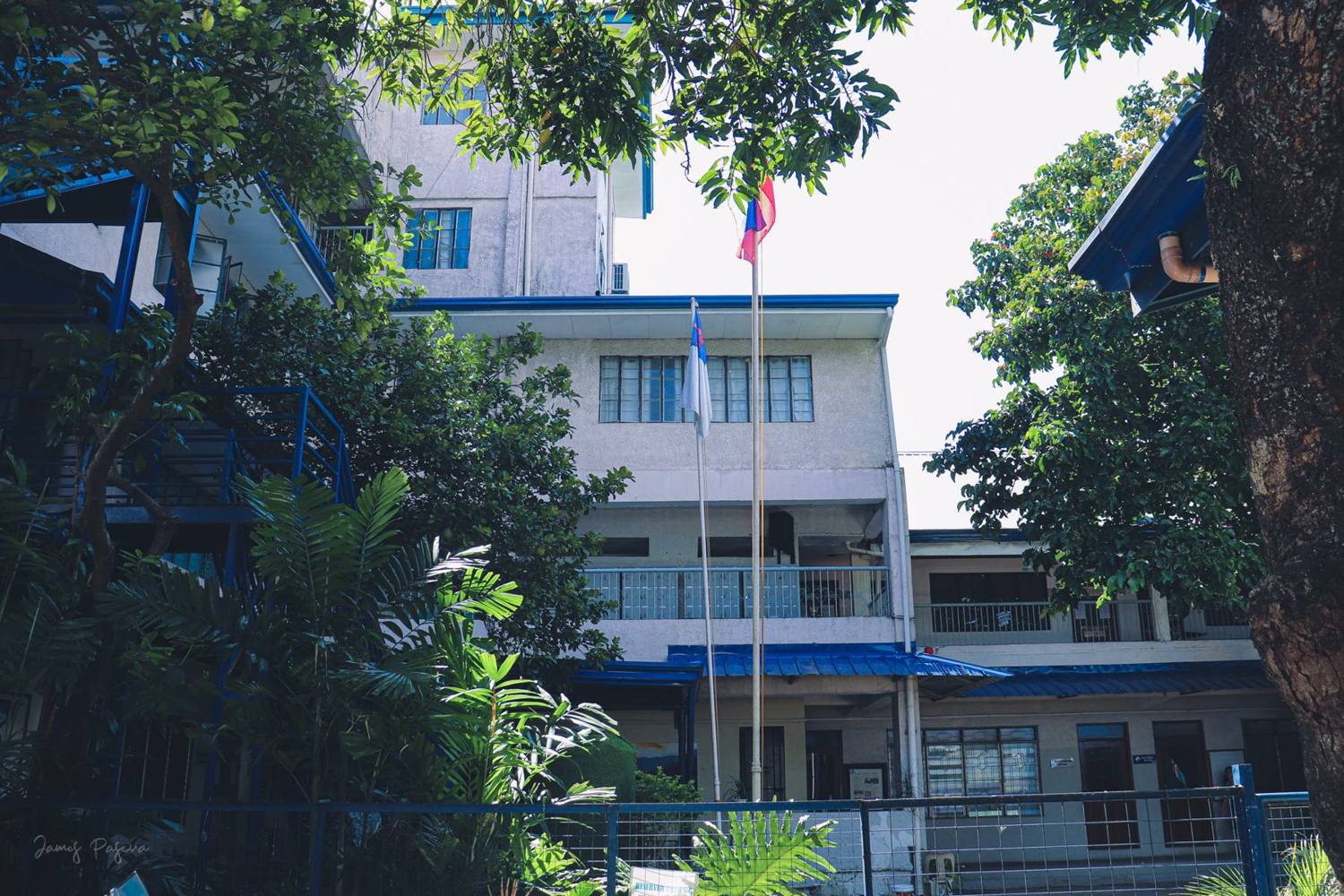 The flag pole and school buildings among the trees
