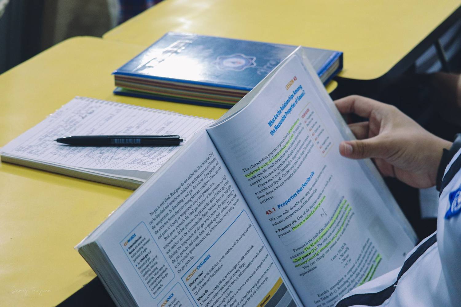 A student reading a textbook in class
