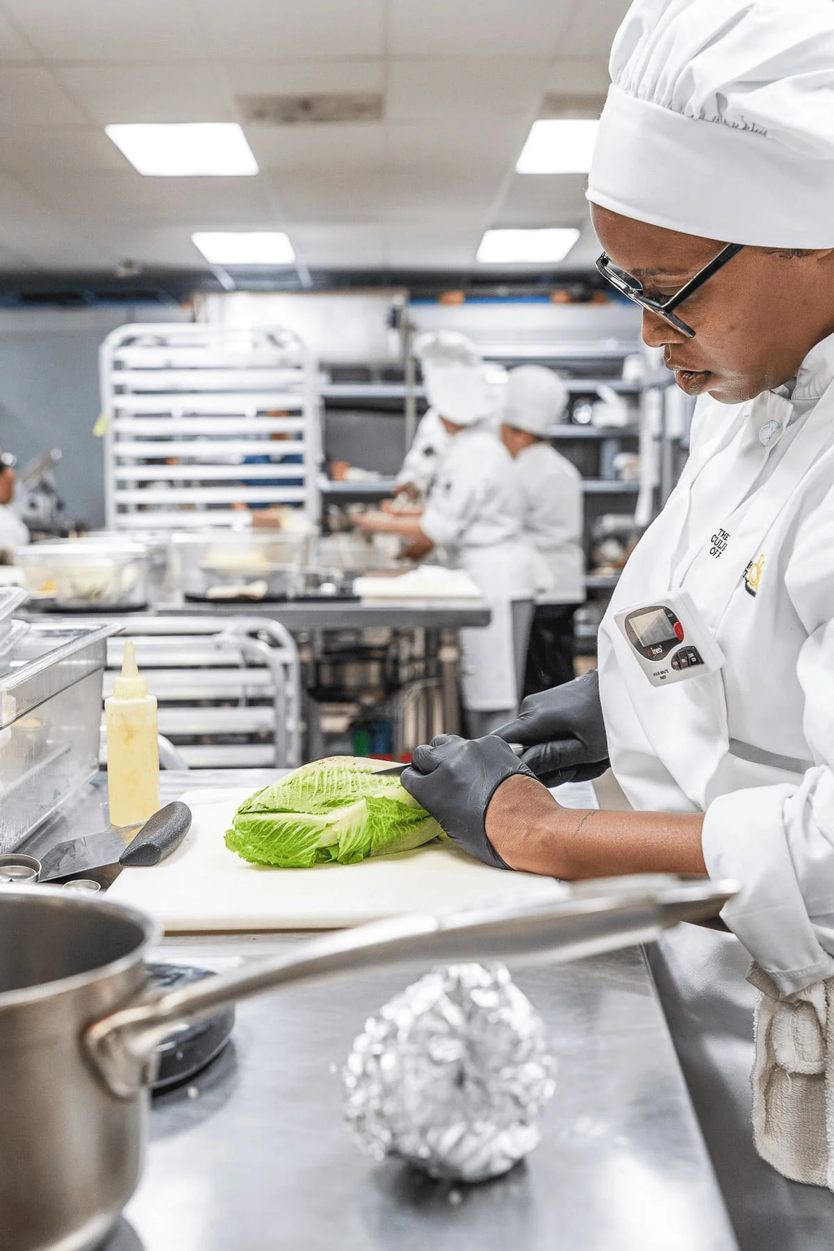 Culinary instructor demonstrating cooking techniques to evening students