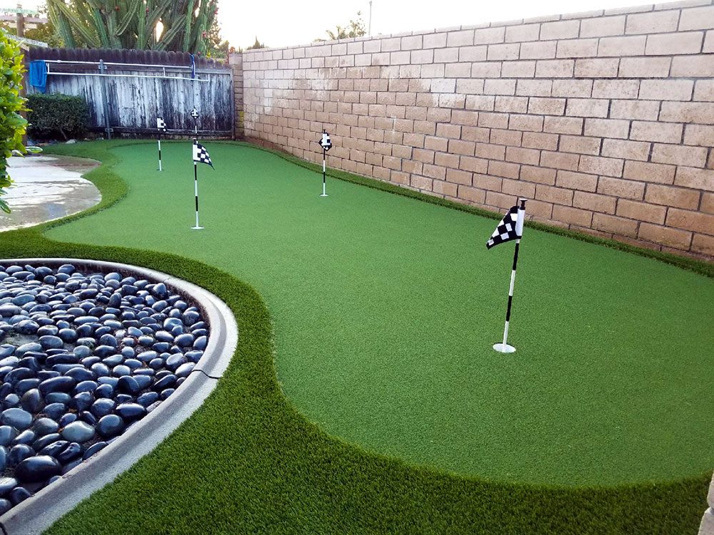 Lengthy custom putting green installation with turf borders