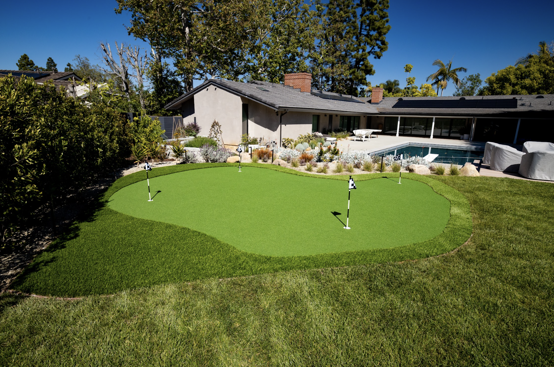 Custom putting green with pool in background