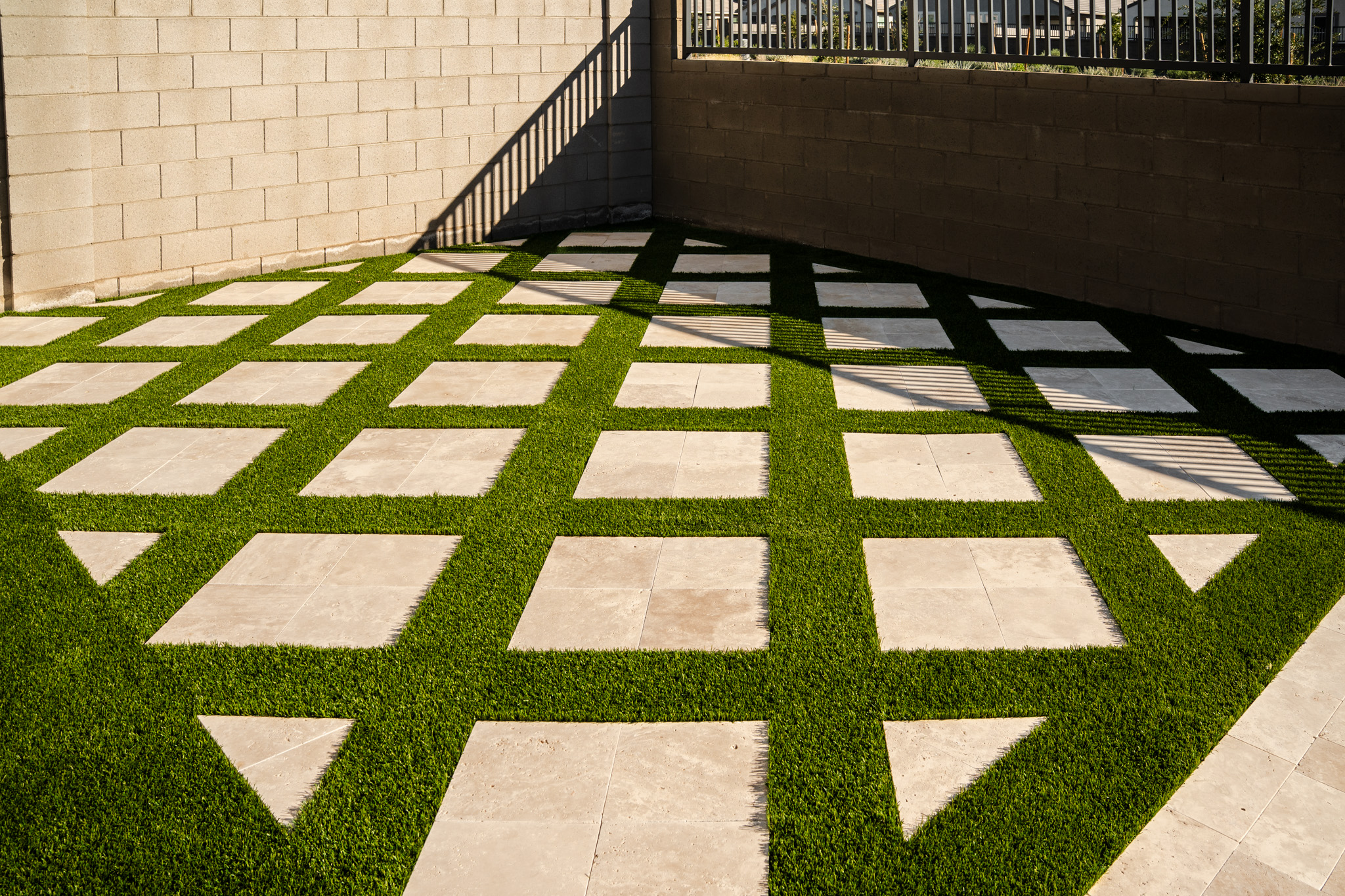 Travertine Chess Board Styled Backyard Patio with Turf