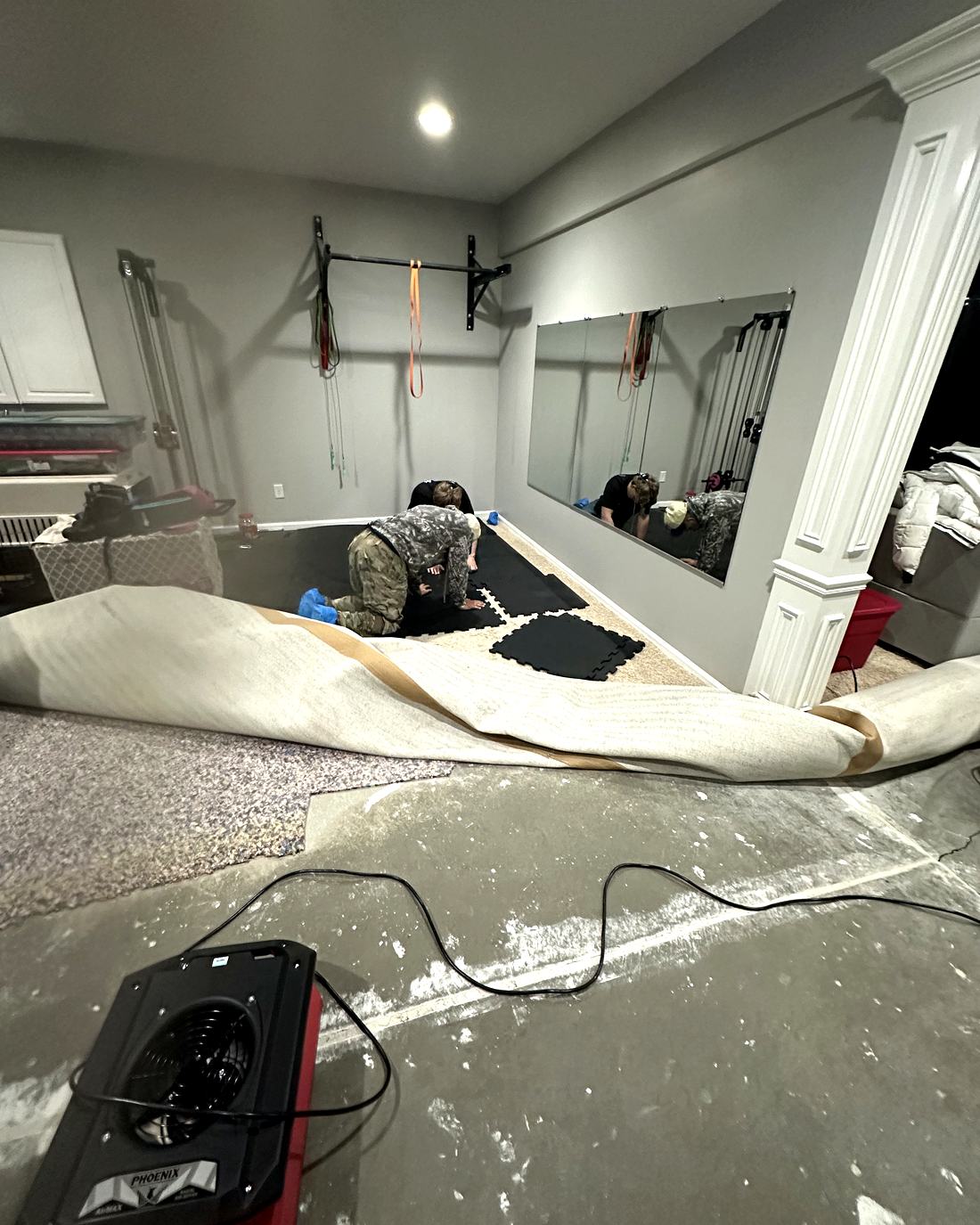 Callie Enterprises technician extracting water and setting professional drying equipment in a Carmel home