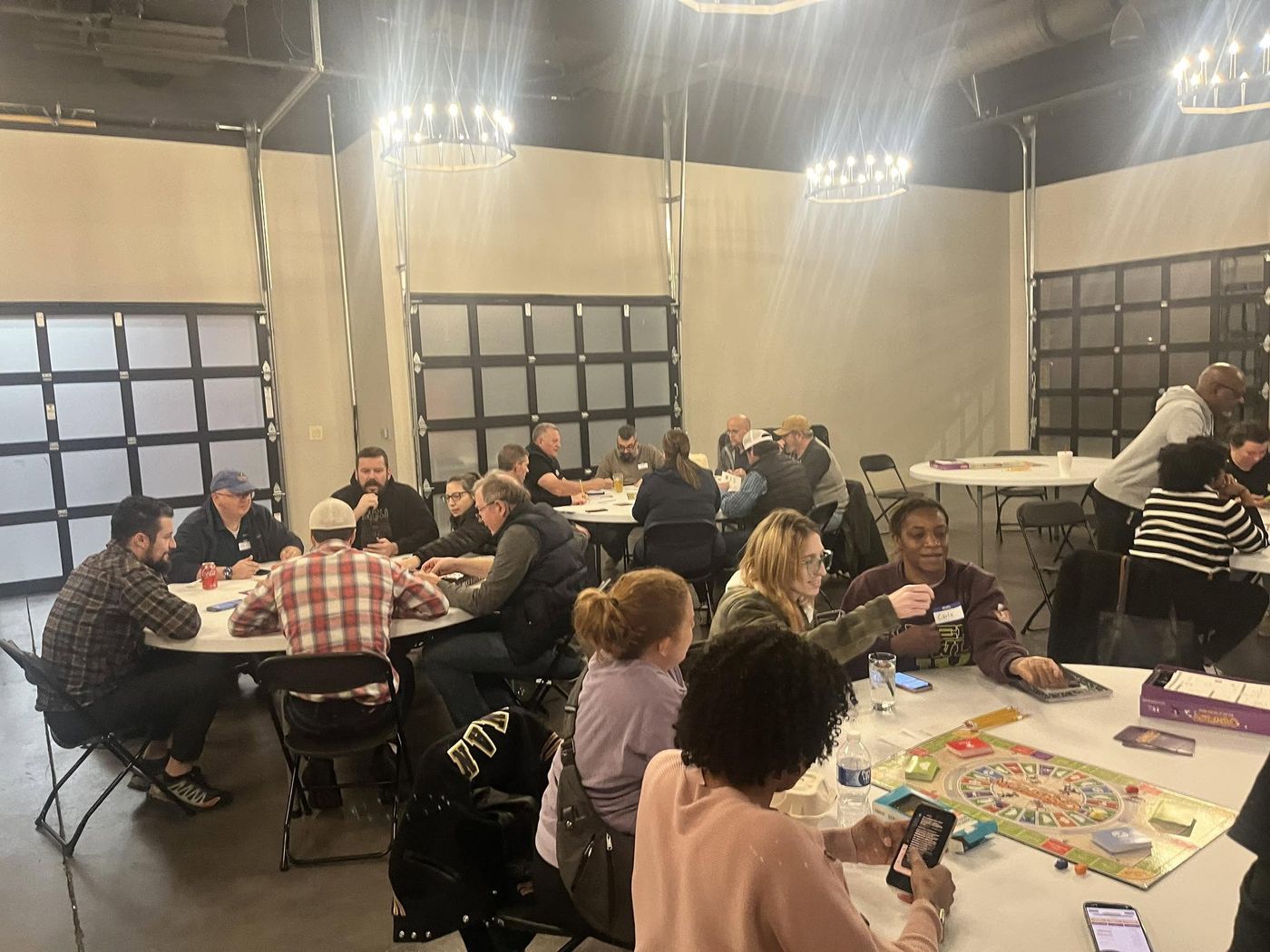 Attendees playing the Cashflow board game at a Dealmaker Atlanta game night