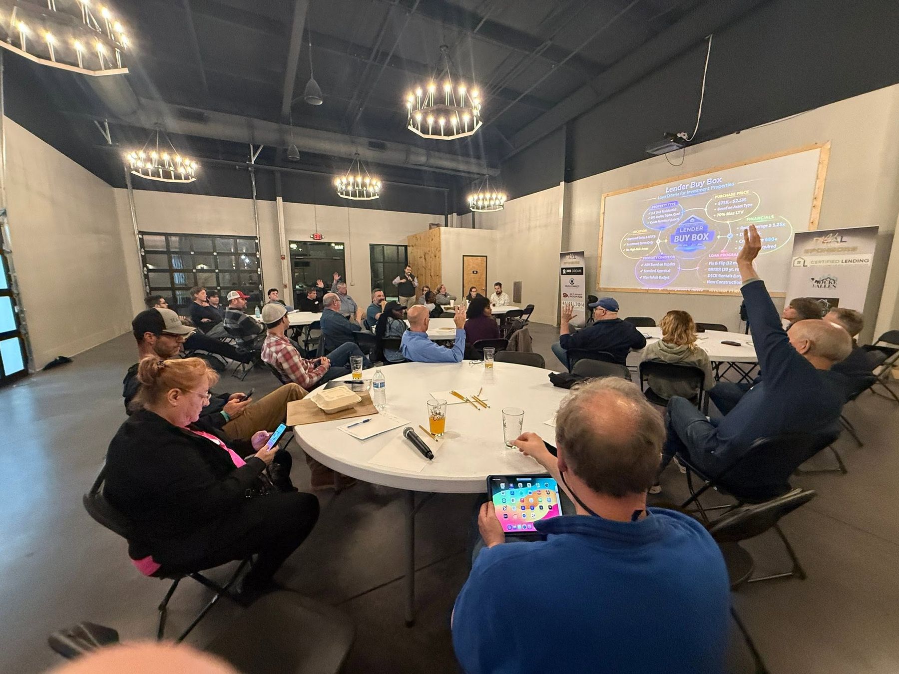 Investors raising hands during a lender buy box session at a Dealmaker Atlanta meetup