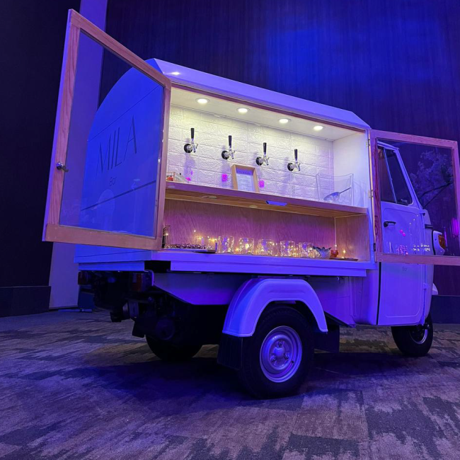 The Mila Bar cart illuminated at an evening celebration