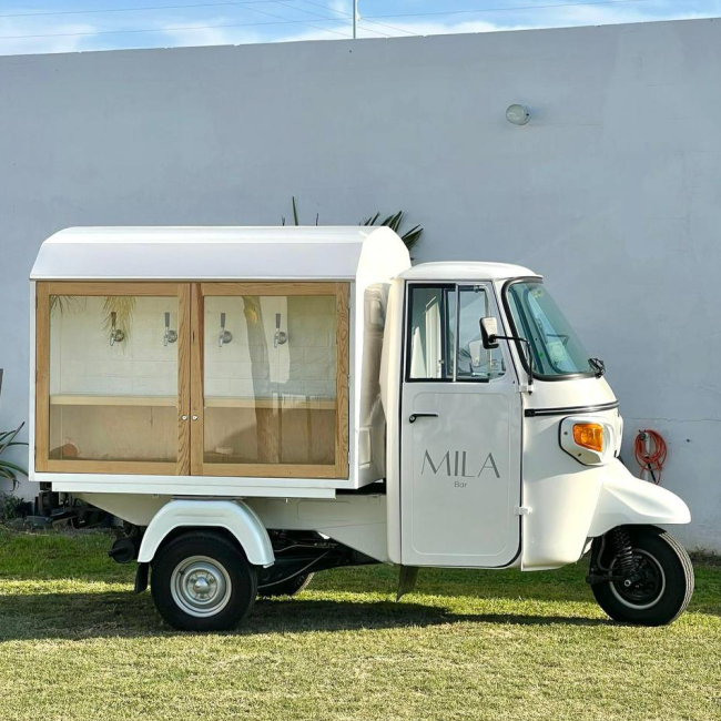 Mila Bar's white four-tap Piaggio Apé on a lawn