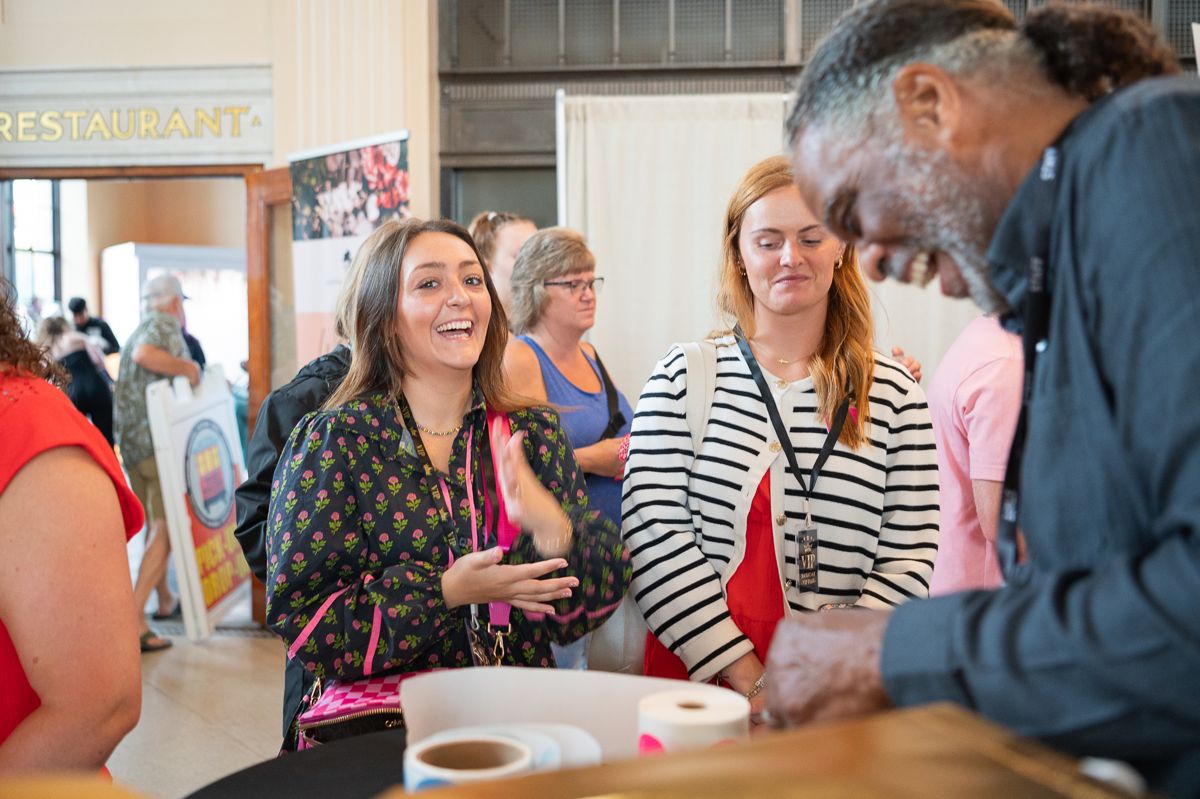 Couples laughing with a vendor at the Carolina Wedding Show