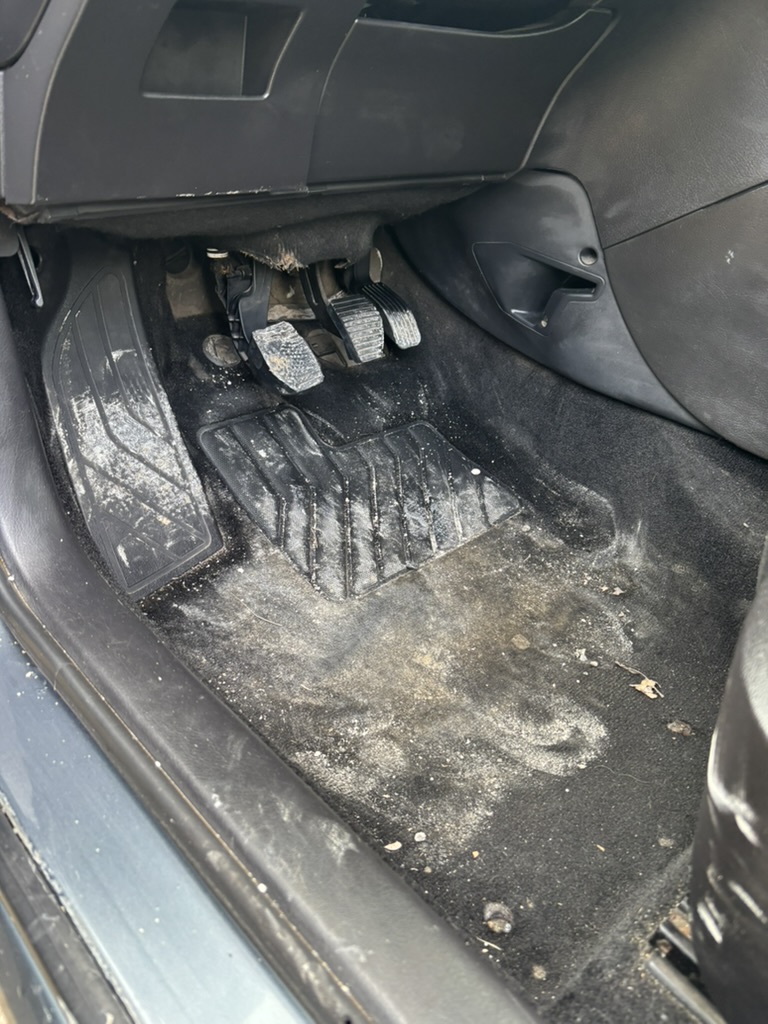 Moquette côté conducteur Peugeot avant nettoyage, avec poussières et débris