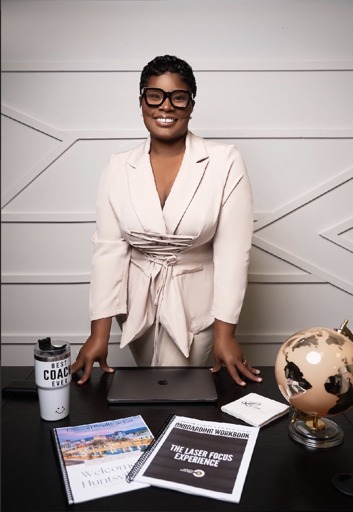 Tajuania Lawson at her desk with the Lawson Realty & Co. onboarding workbook