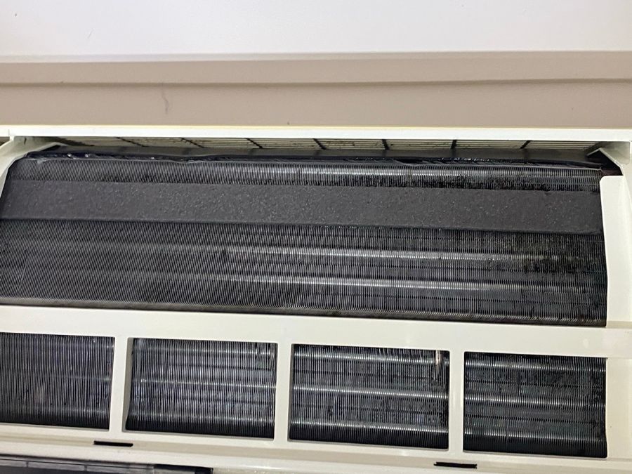 Split system with the front open, coil and filters dark with dust
