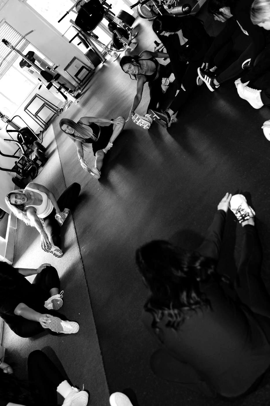 A FORM class stretching in a circle on the turf at CoreFit Wellness